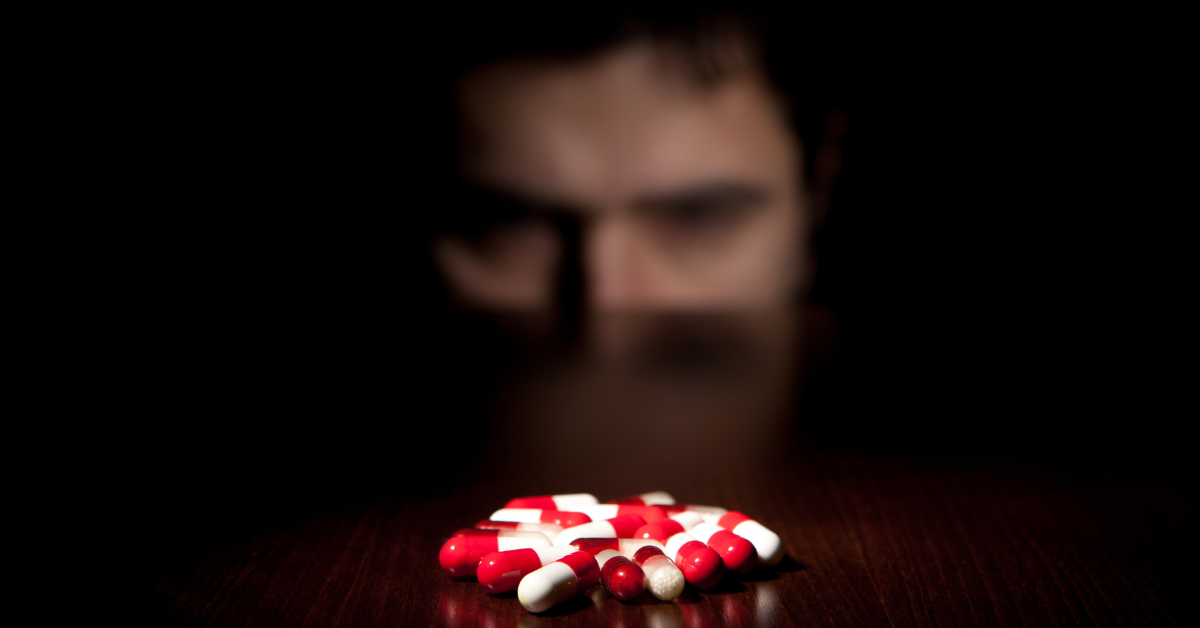 Someone looking at a pile of pills on a table