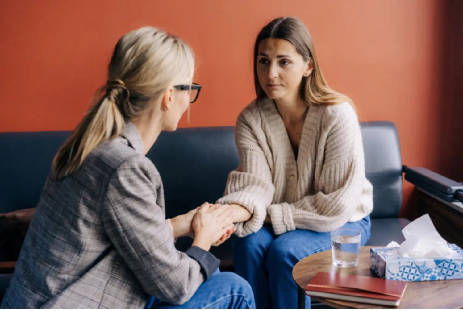 Therapist comforts patient and holds her hand